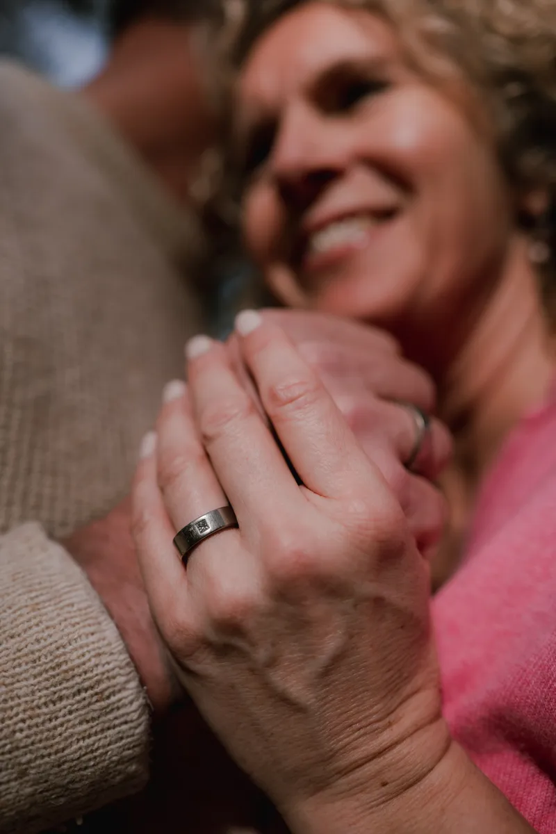 Twee handen die elkaar vasthouden, een vrouw lacht