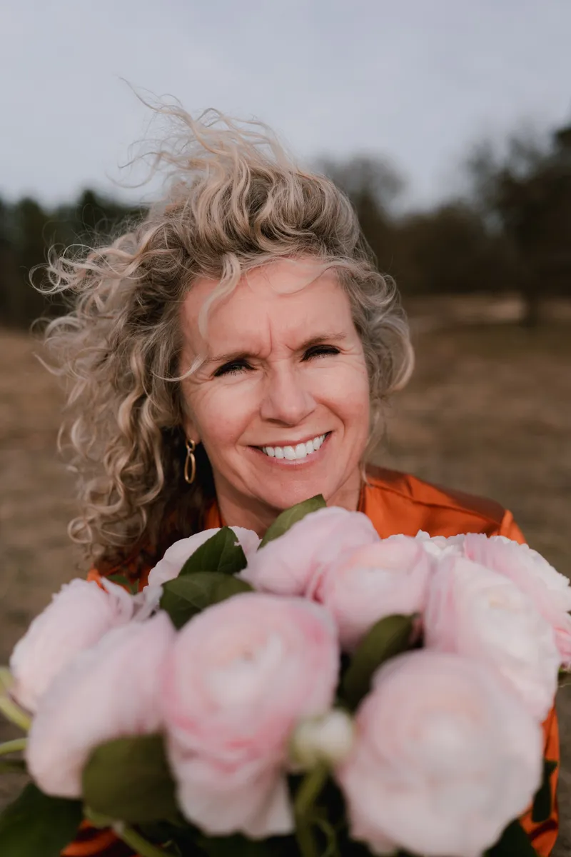 Marcella Hagenaar met een bos pioenrozen op de hei